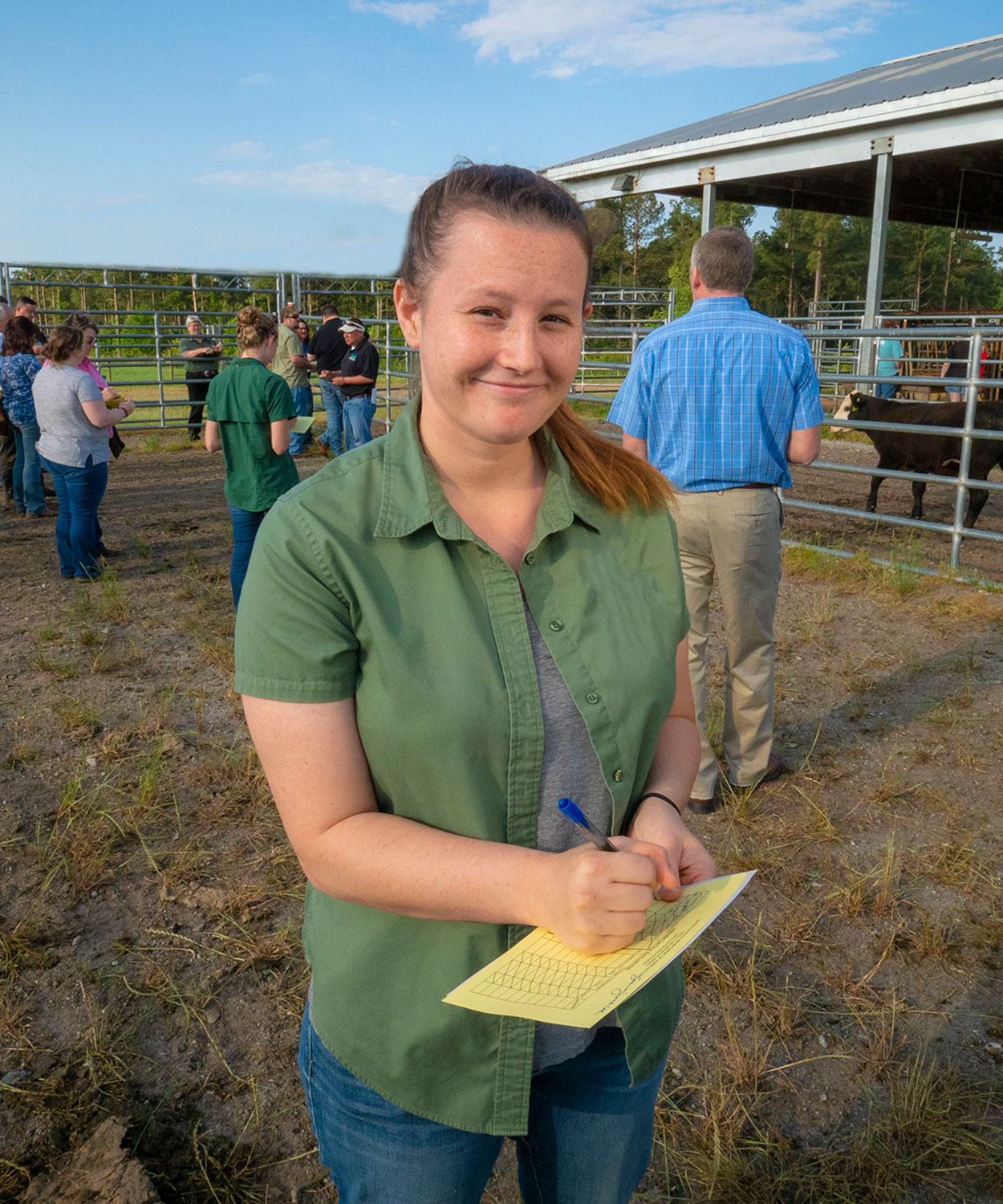 Young, female rancher hosting a small tour group.