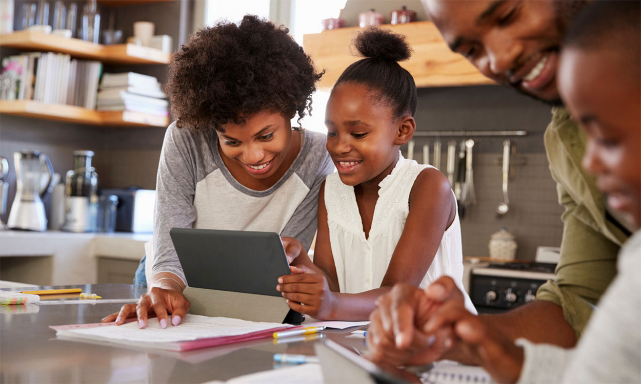 Family reviewing budget materials at a kitchen table.