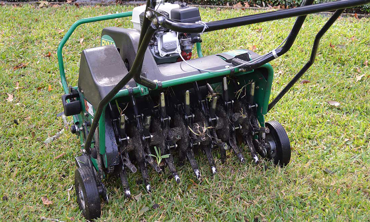 Gas-powered lawn aerator on lawn.