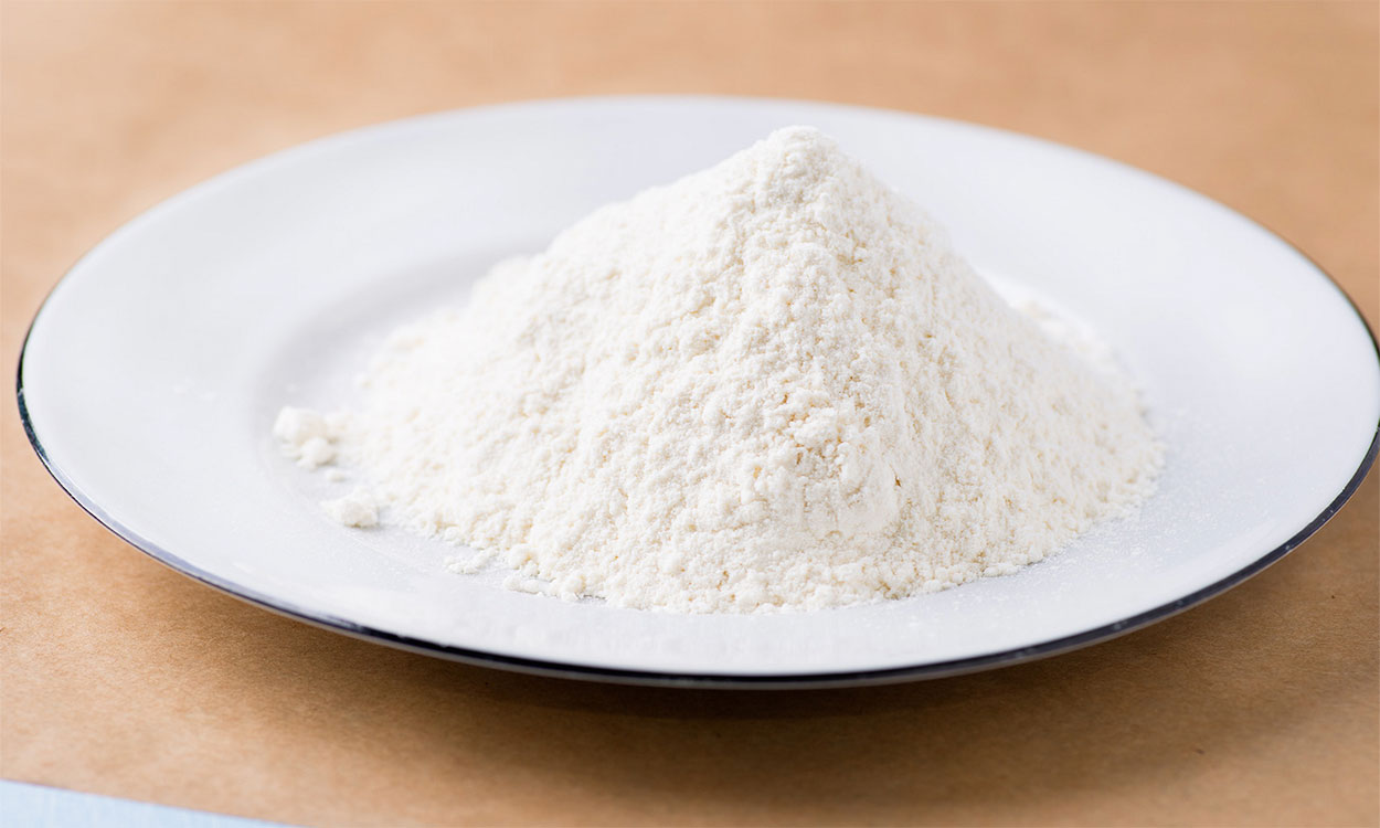Small pile of flour on a white plate.