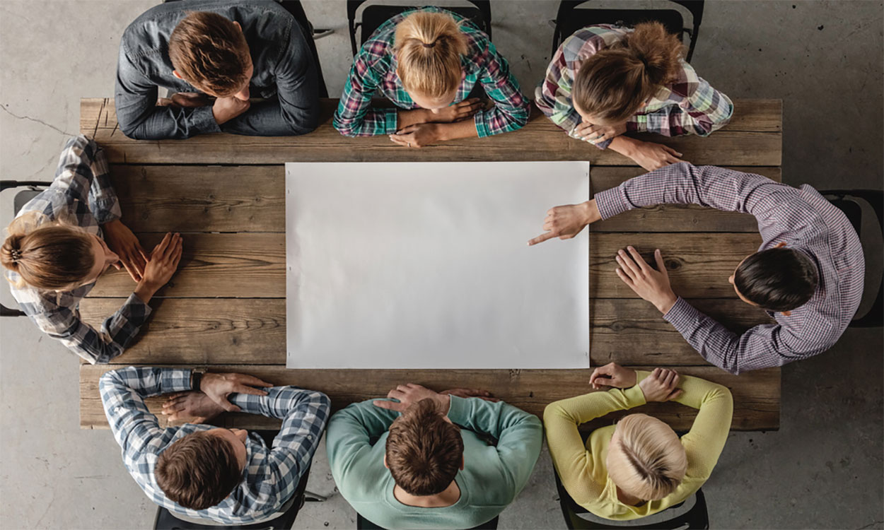 Small group of young professionals gathered around a meeting table.