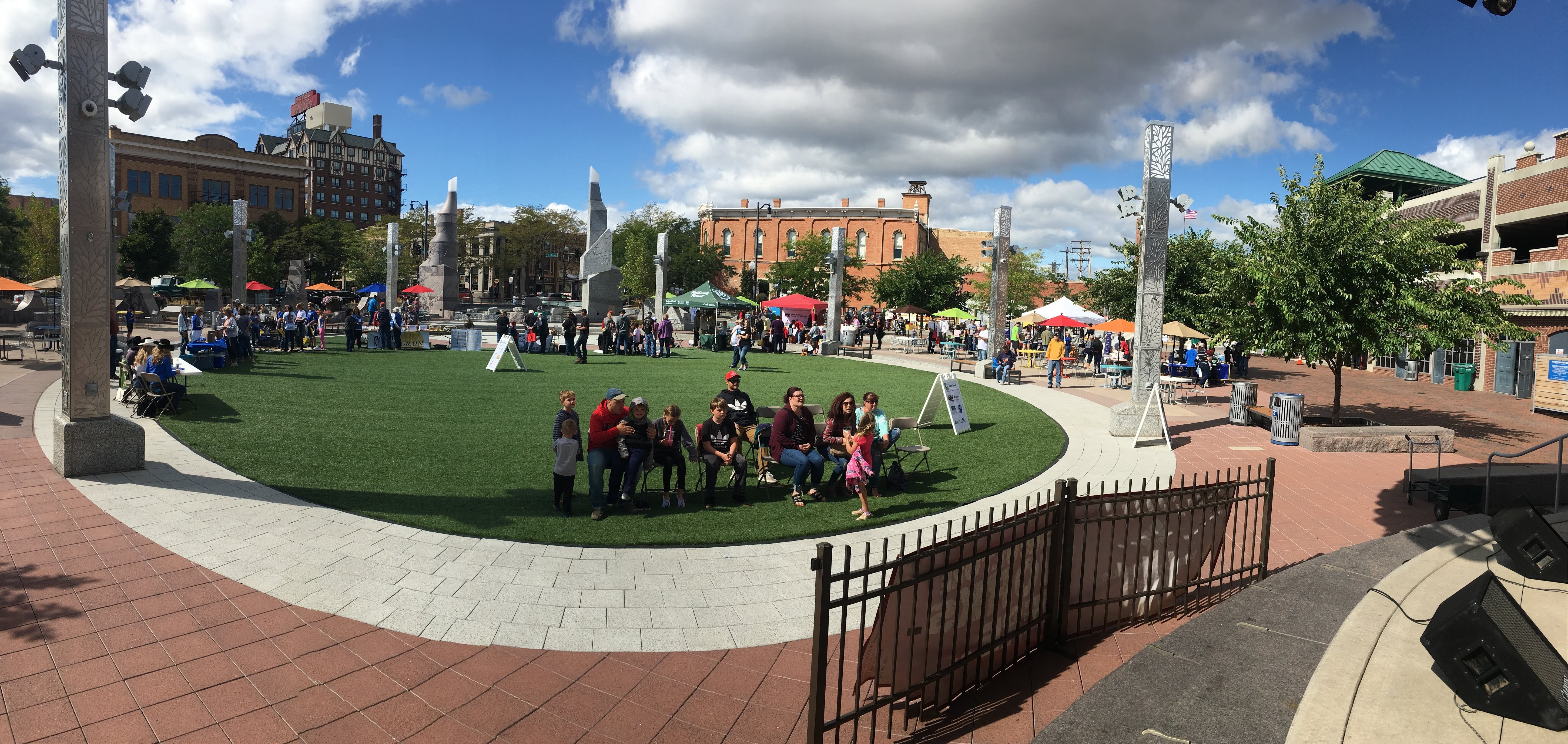 a bigger group of people in a town square doing various things