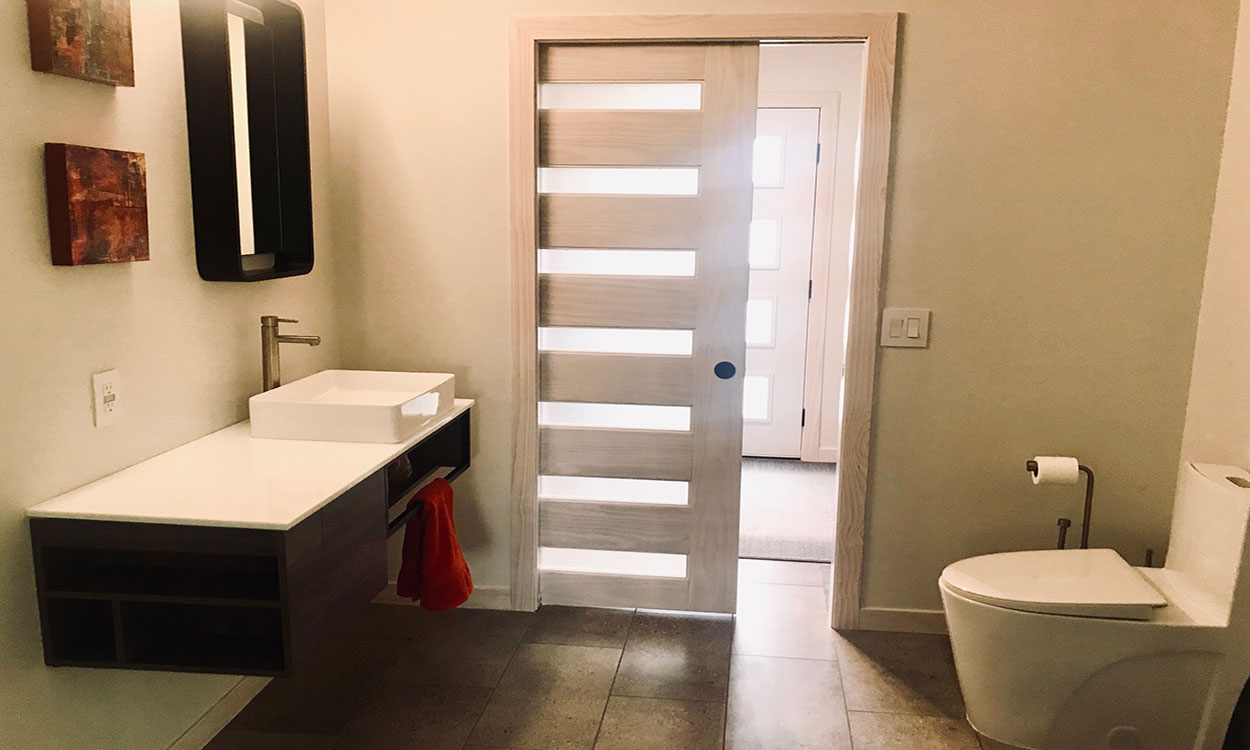 Modern, adaptable bathroom design. A wheelchair user has access to all key functions in the bathroom including the shower, commode and sink.