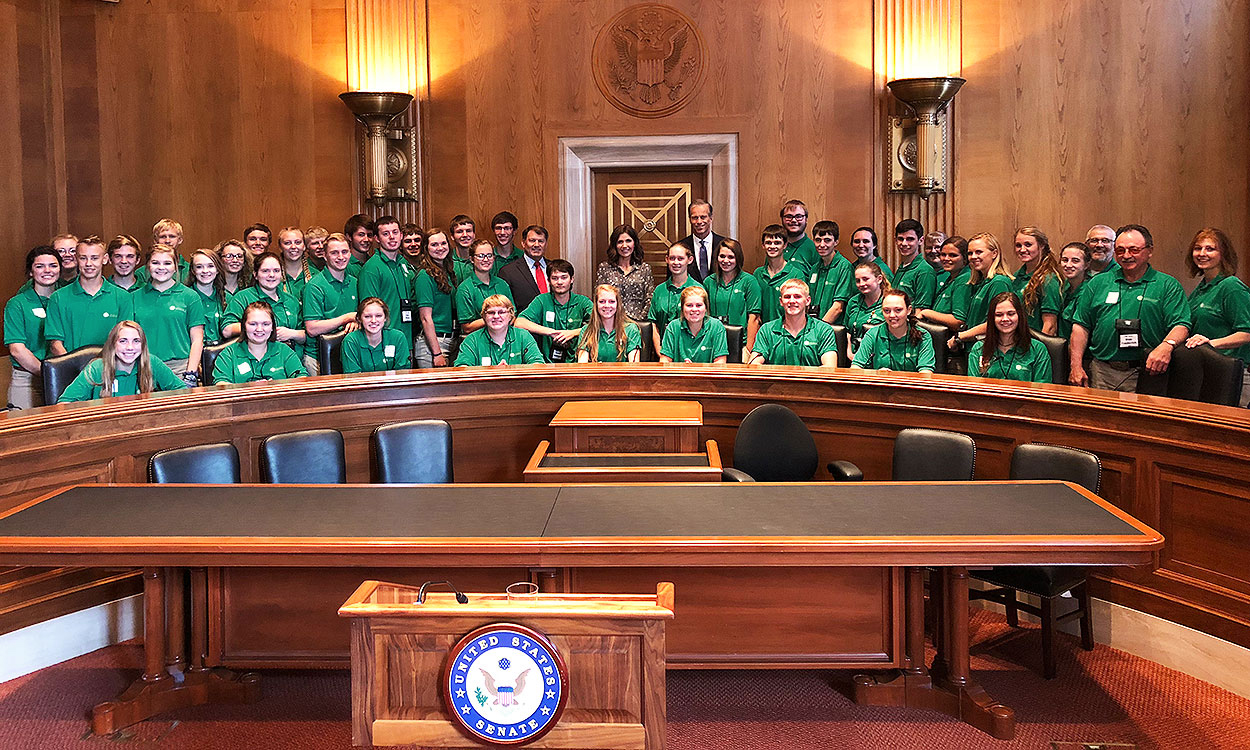 Citizenship Washington Focus delegates and chaperones in the U.S. Senate Chamber with Senators John Thune and Mike Rounds and Governor Kristi Noem.
