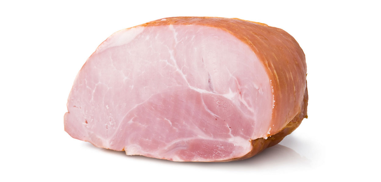 Whole ham resting on a white countertop.