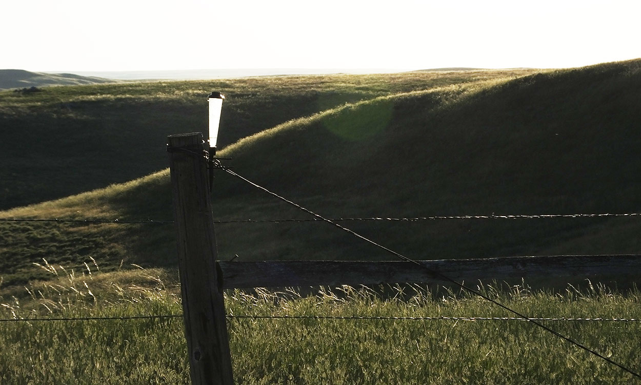 Rain gauge on a fencepost along a well-managed rangeland.