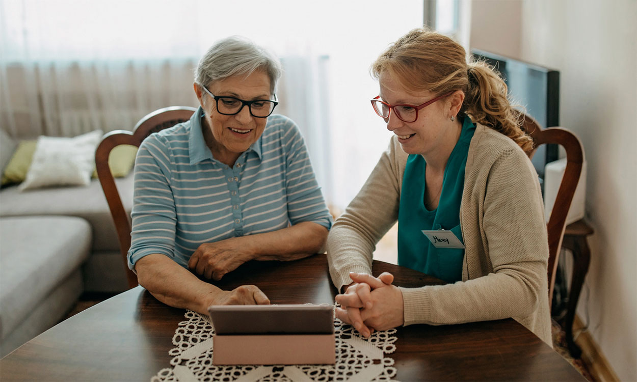 Home health care specialist visiting with an older female adult.