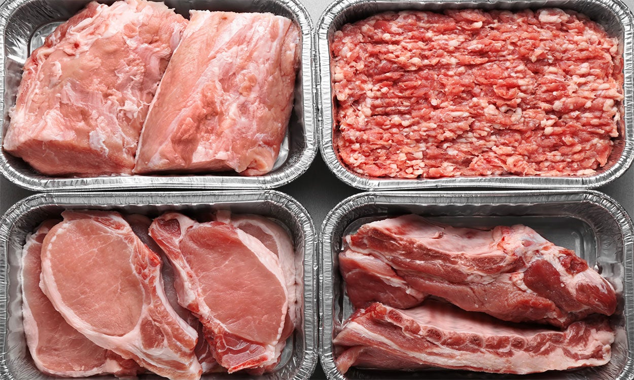 Variety of pork products in tinfoil trays.