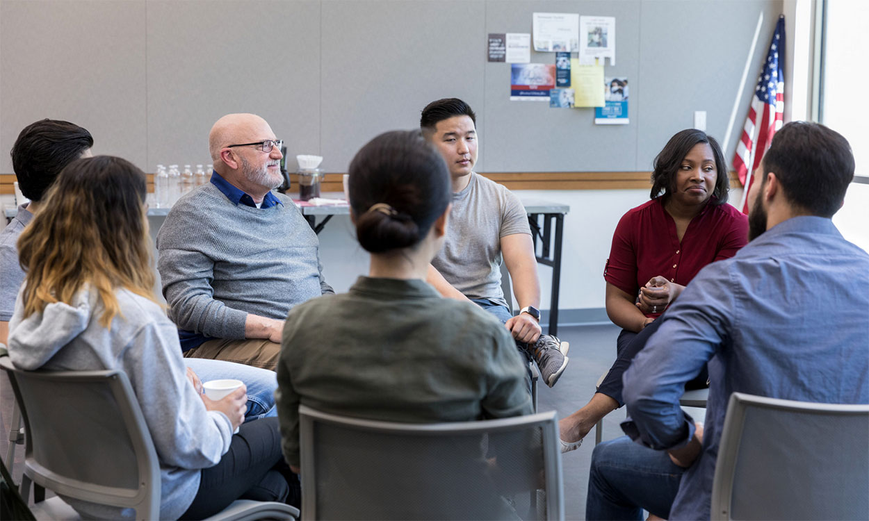 Diverse group of townspeople meeting in a small group.