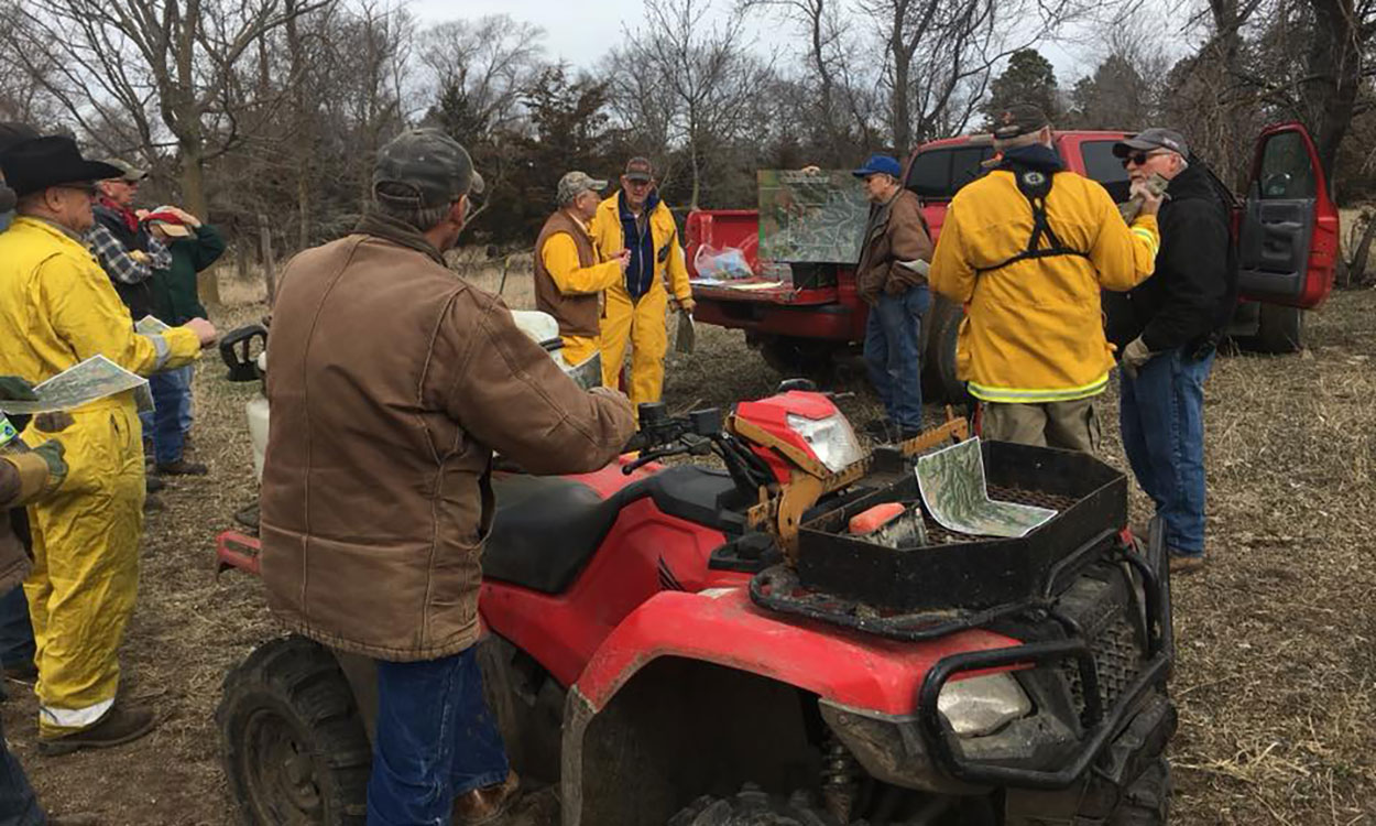 Tom Hausmann gives a briefing before the burn, while Greg Schmitz listens with the rest of the burn crew.