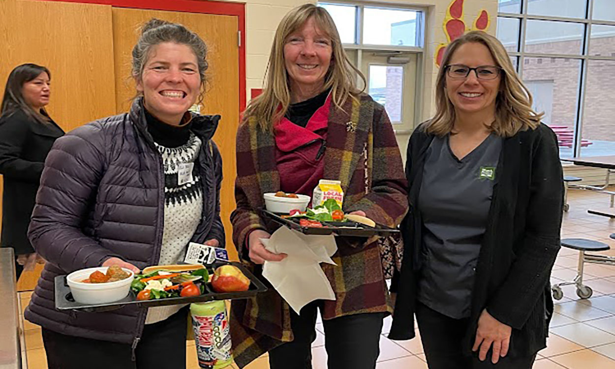 Local farm to school team members in a school cafeteria.