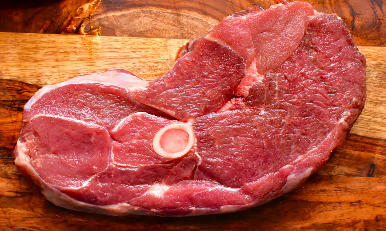 Lamb leg steak on cutting board.
