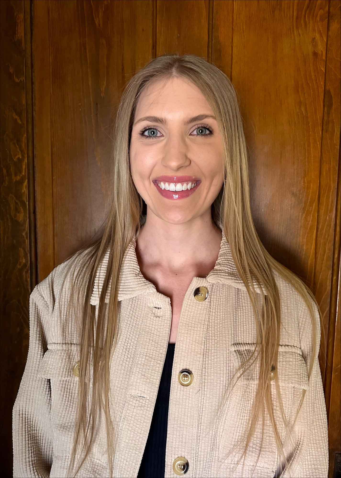 Whitney Keller Reetz stands in front of a wall