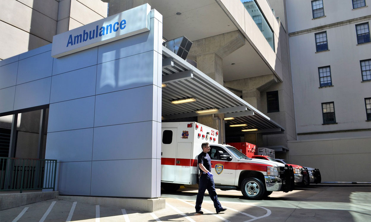 Emergency medical technician walking near an emergency room entrance.