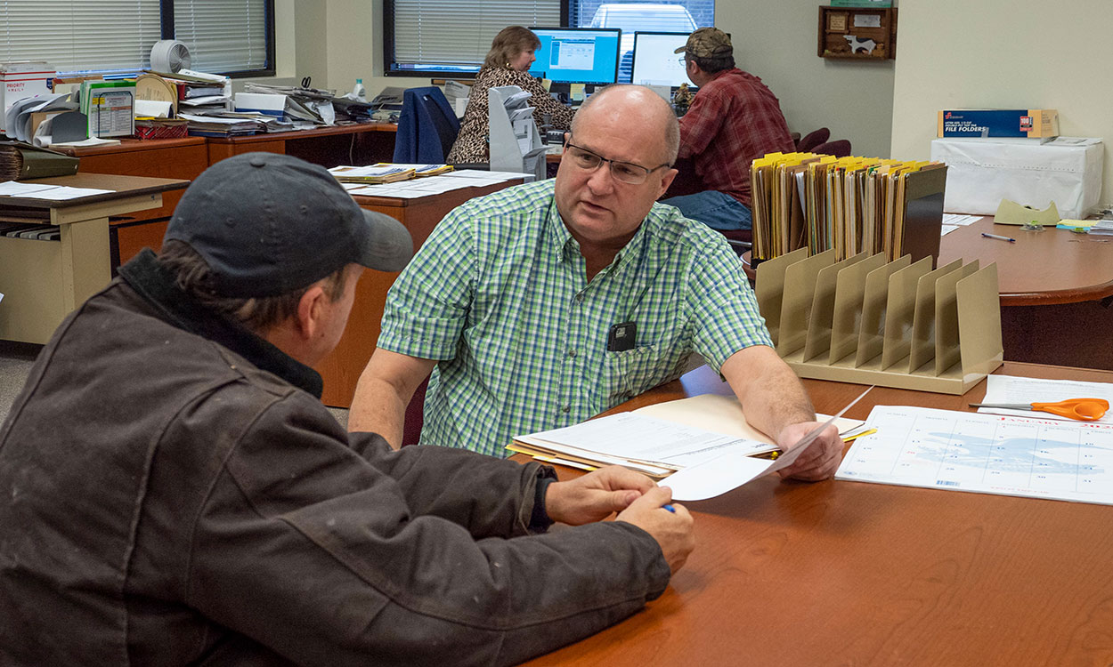 Producer reviewing an aid application with a USDA FSA agent.