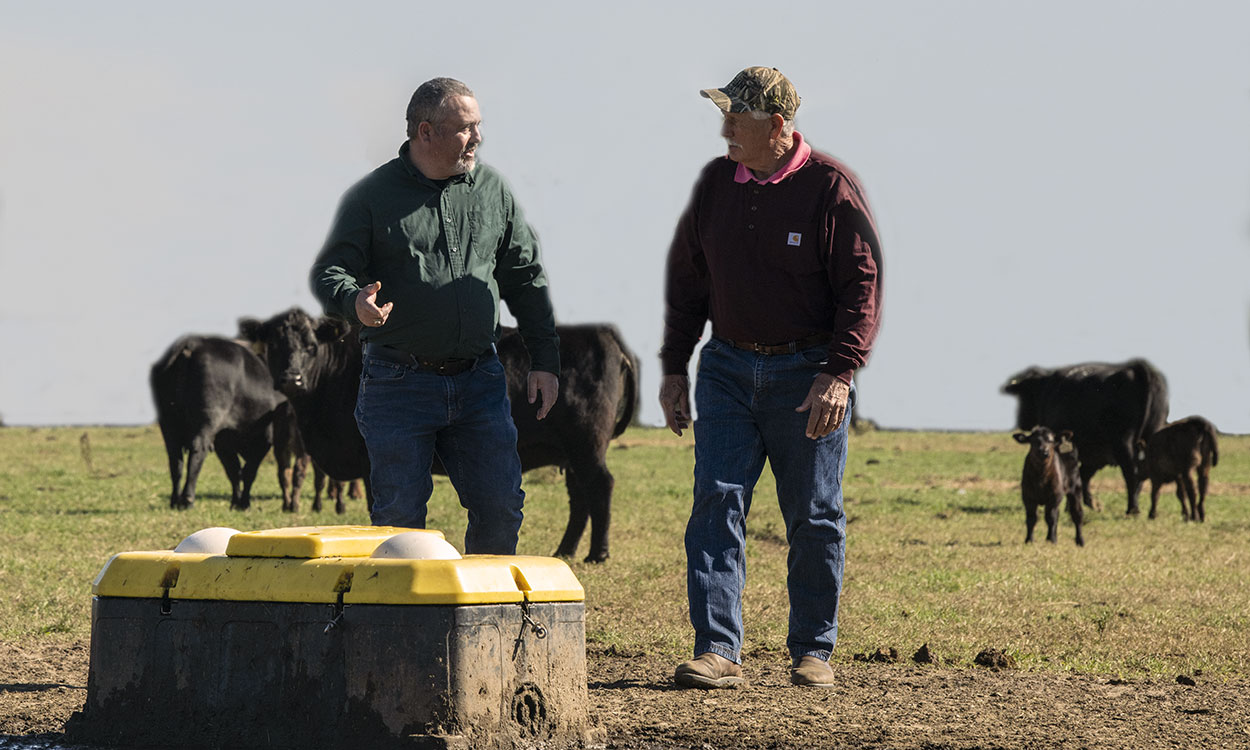 Two producers observing an in-field cattle watering unit.