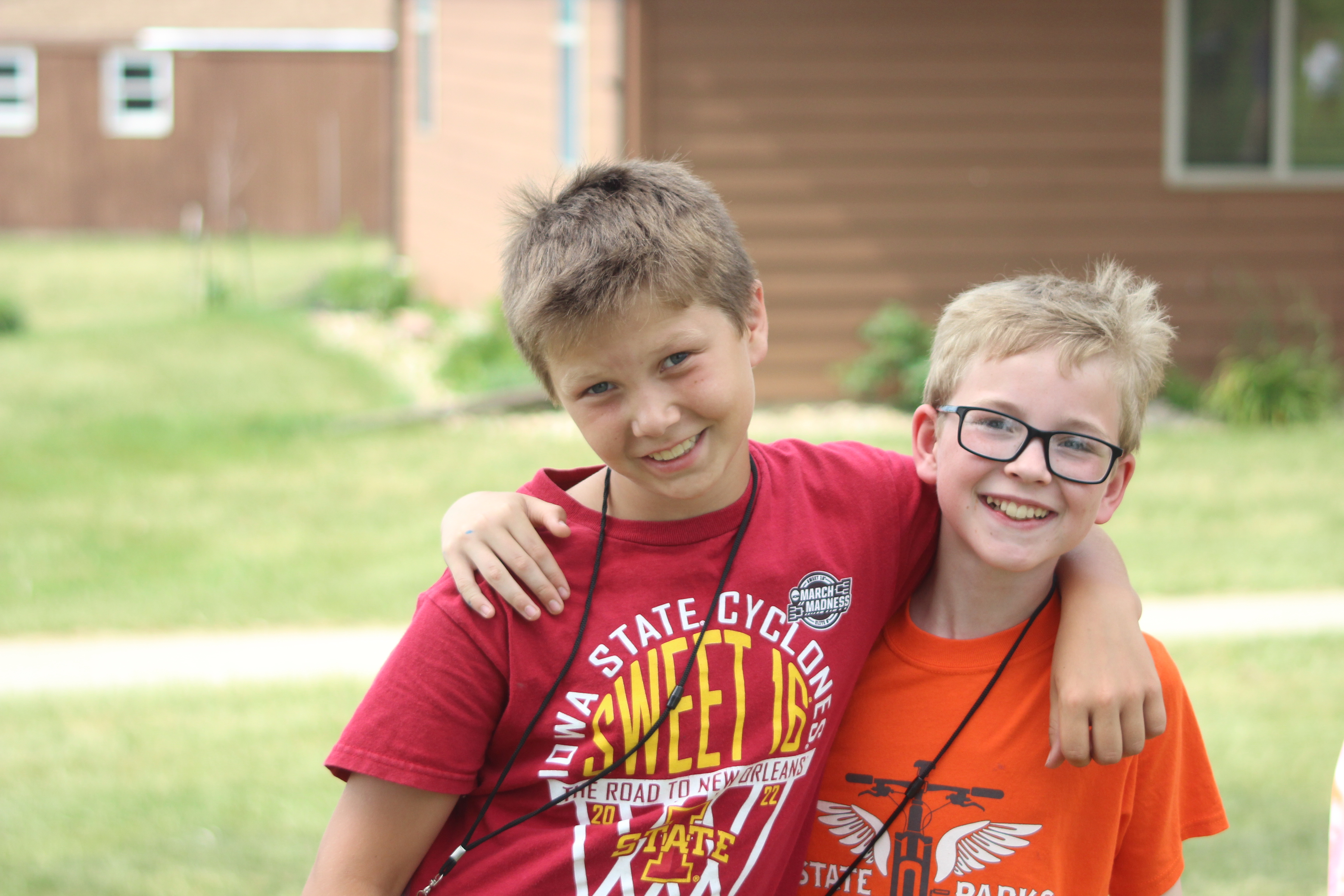 Two youth with their arm around each other at camp