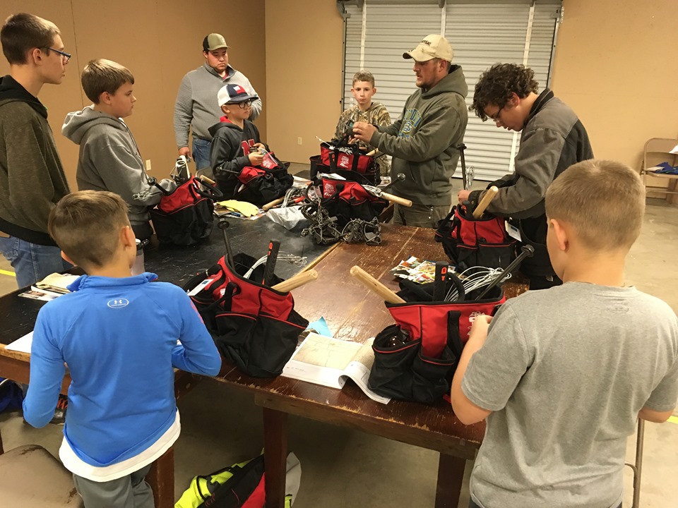 Group of youth learning how to make outdoor kits