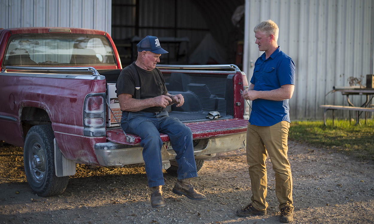 An older producer and his grandson having a discussion on their family farm.