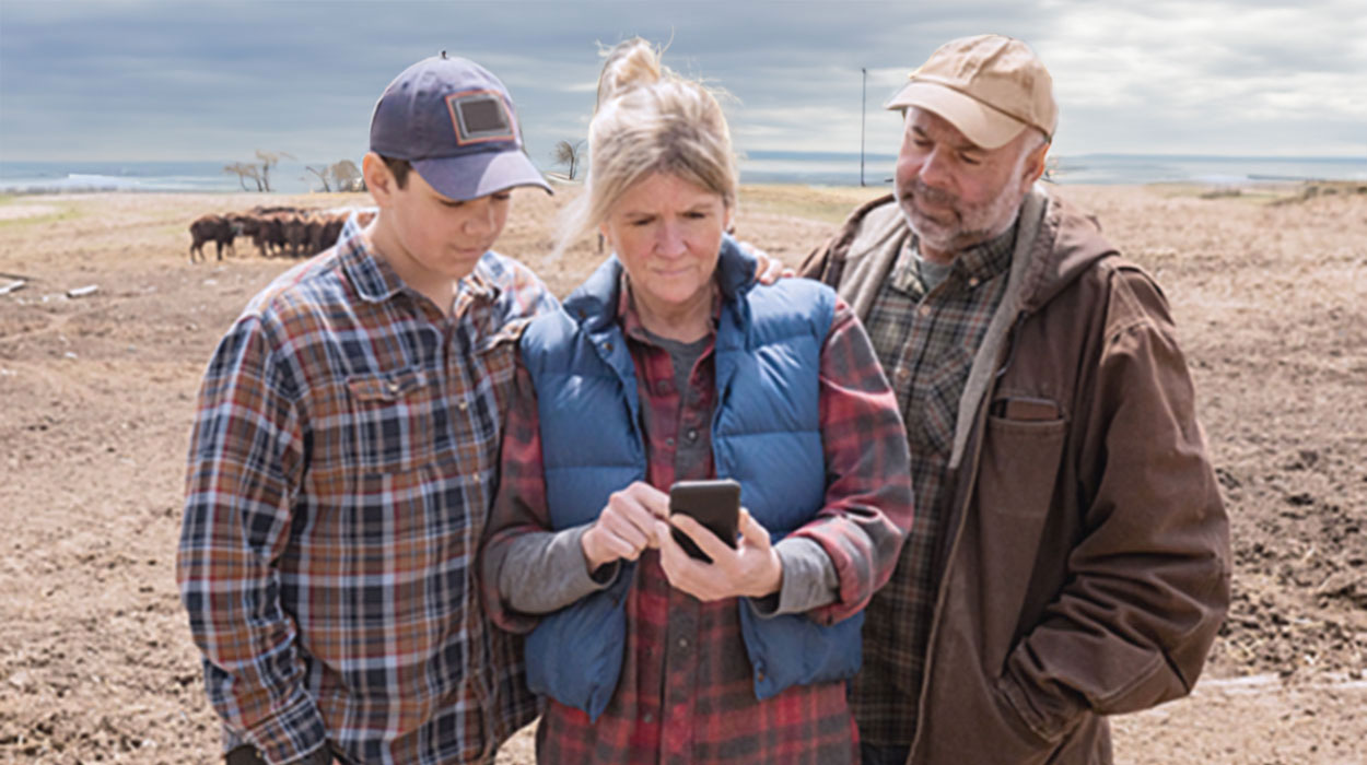 Ranch family examining data on a smart phone.