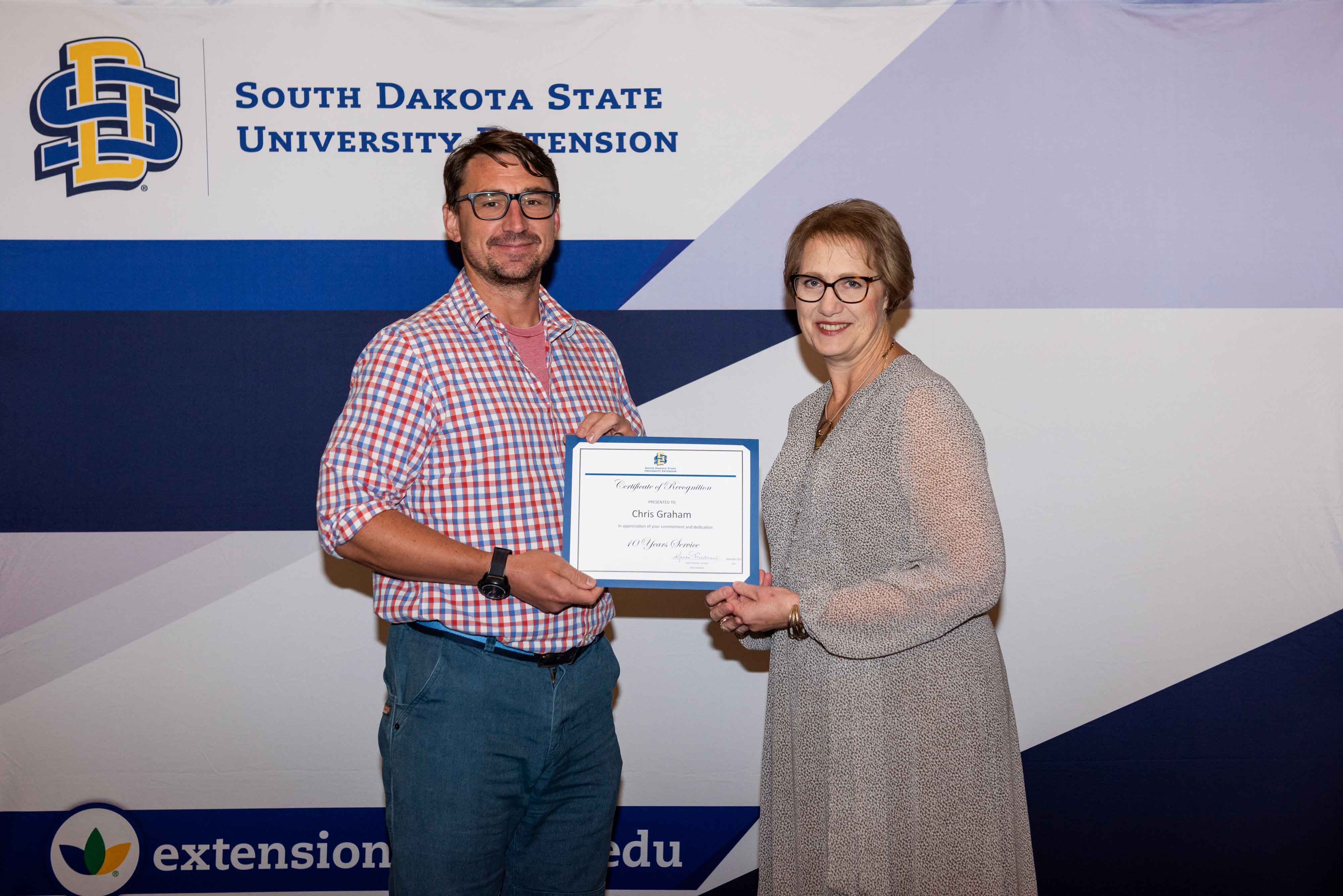 Chris Graham receives a certificate from Karla Trautman