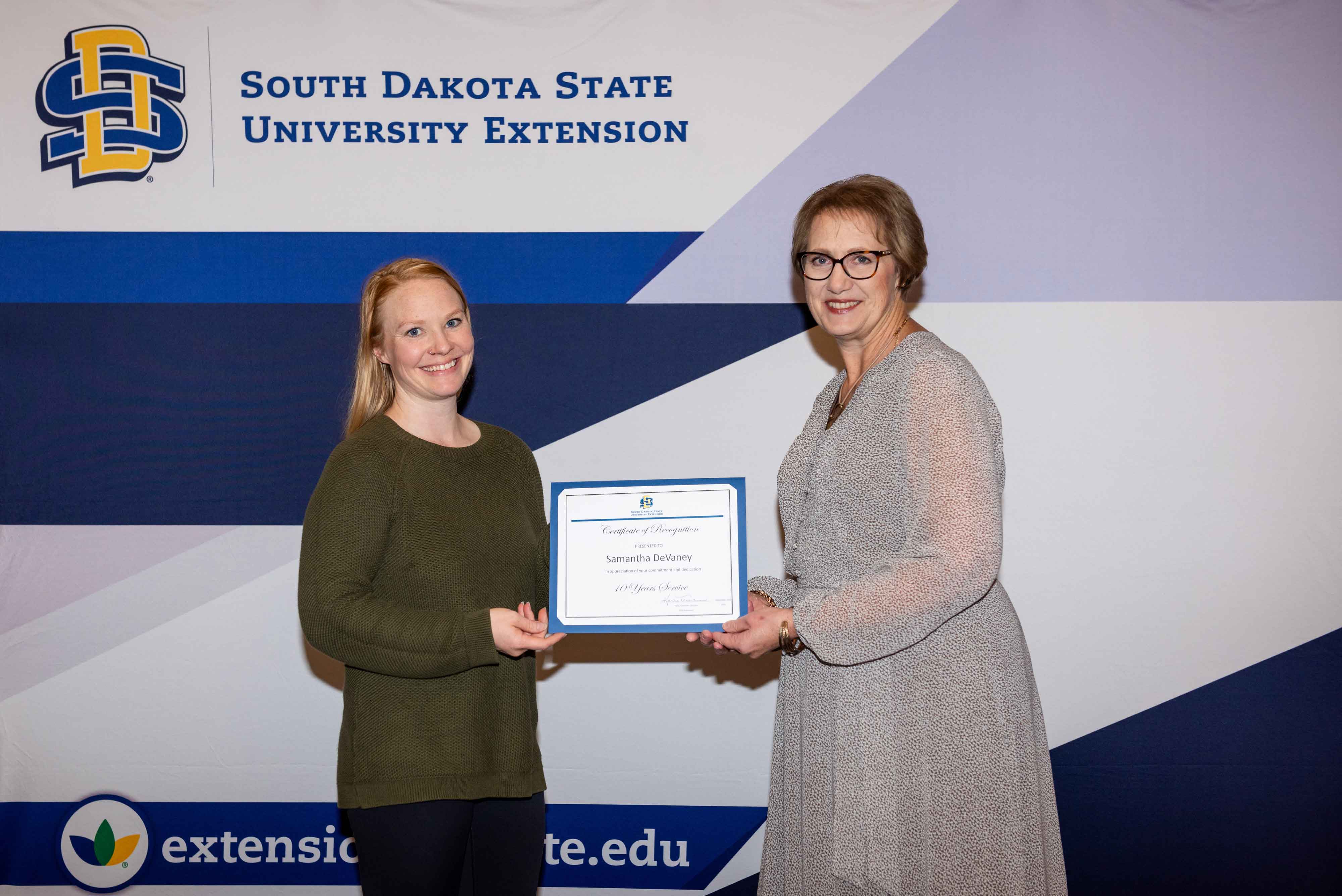 Samantha DeVaney receives a certificate for 10 years of service from Karla Trautman