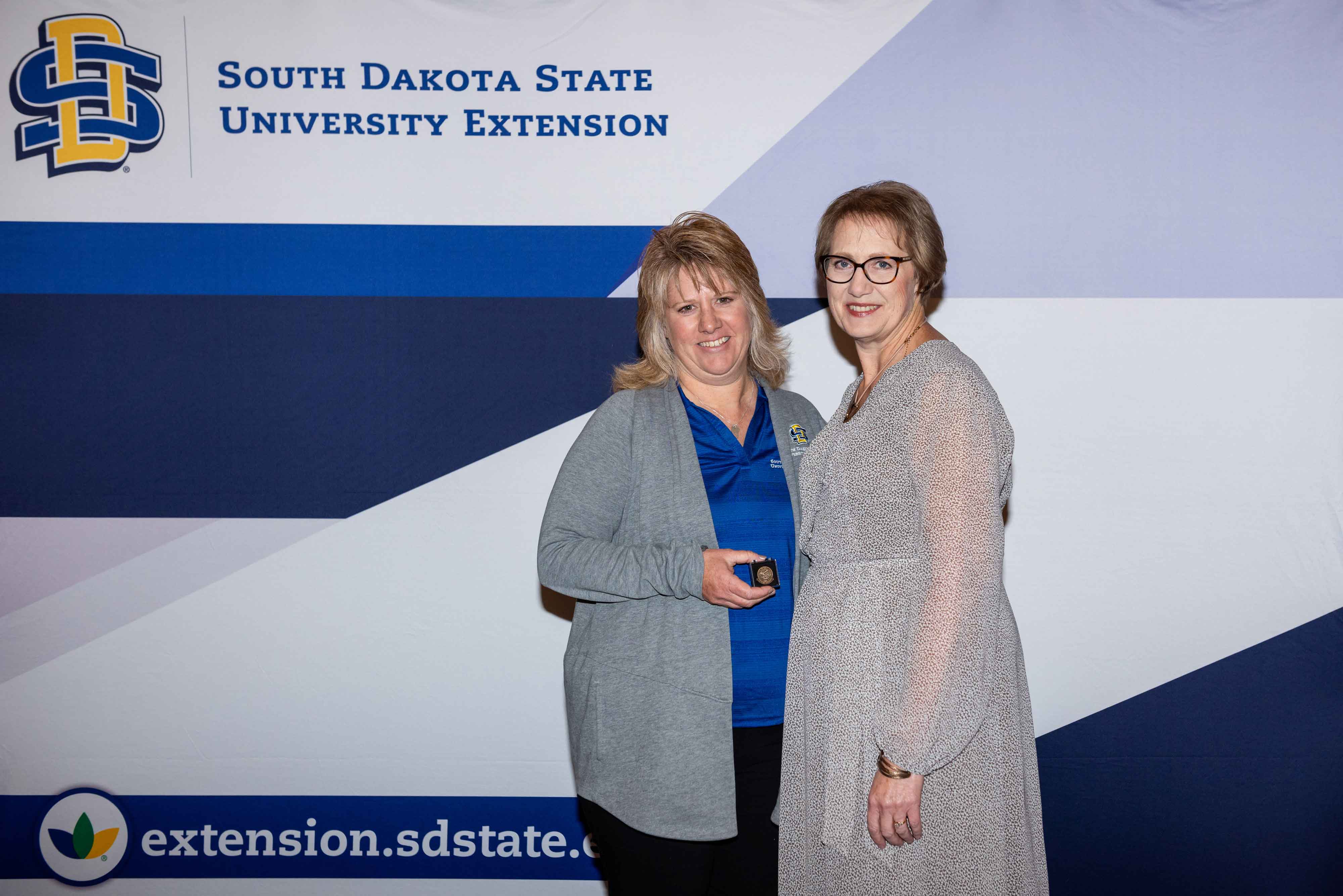 Deanna Gall receives a pin for 25 years of service from Karla Trautman