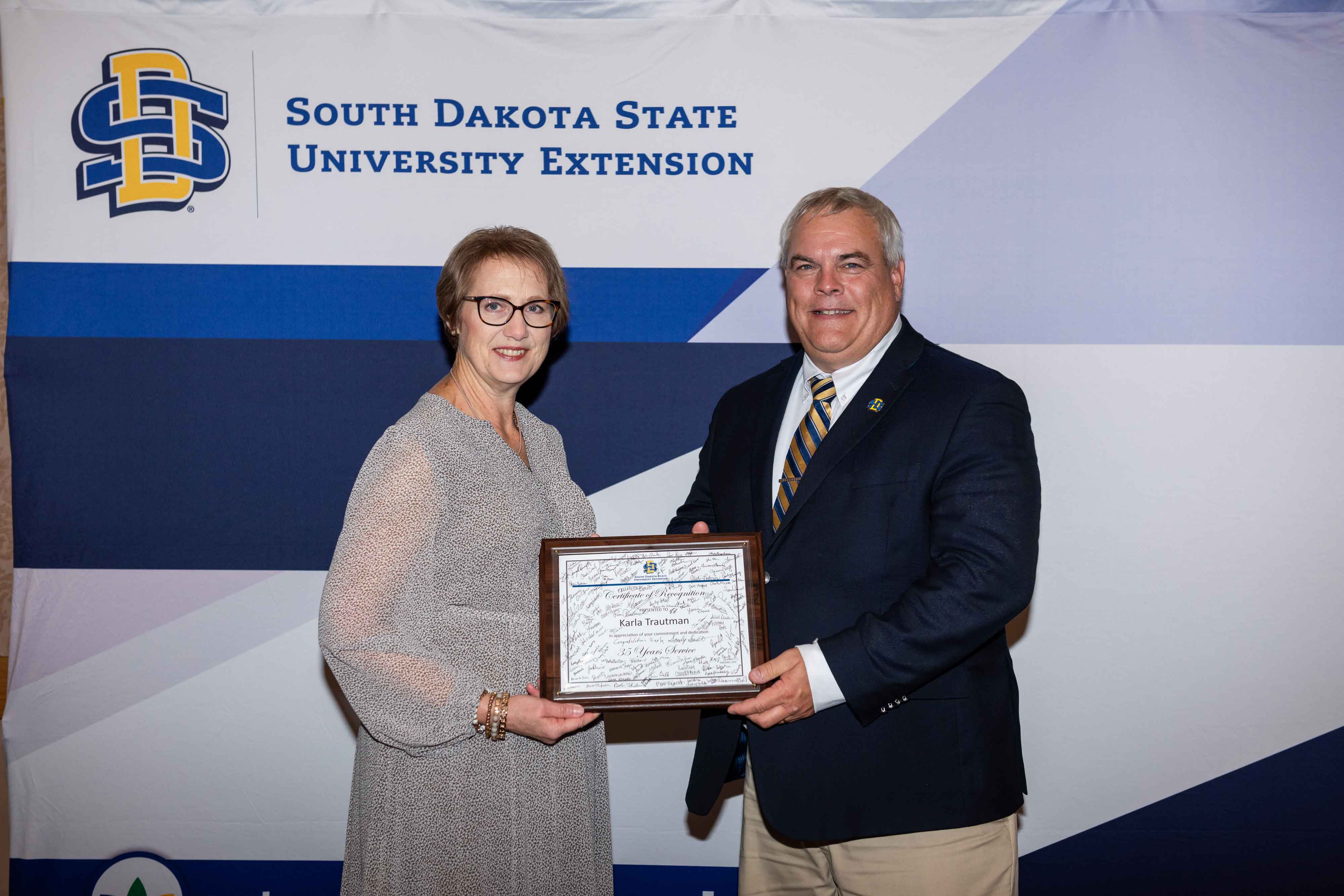 SDSU Extension Director Karla Trautman receives a certificate recognizing her 35 years with SDSU Extension from Joseph Cassady, South Dakota Corn Endowed Dean of the College of Agriculture, Food and Environmental Sciences at SDSU