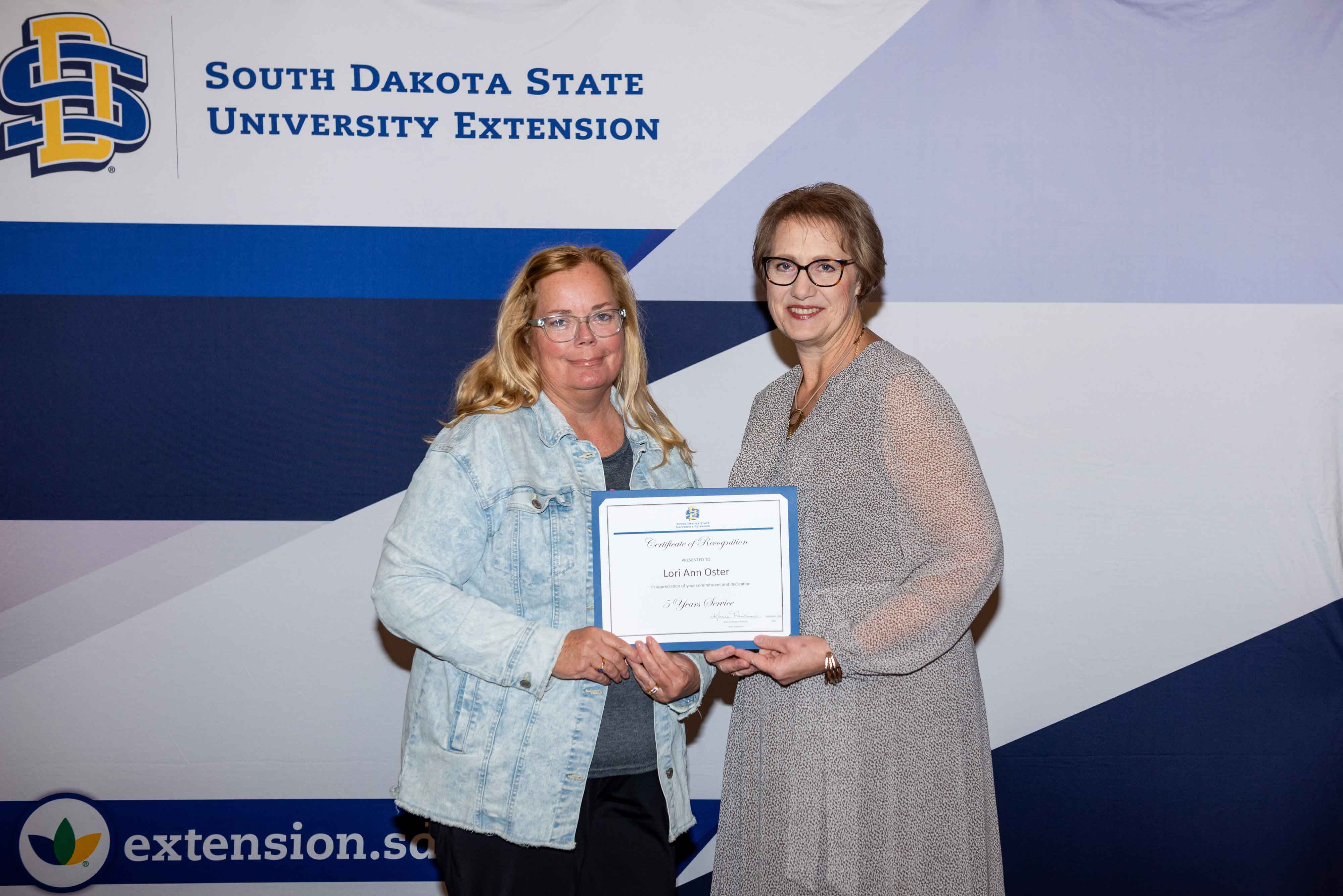 Lori Oster receives a certificate for 5 years of service from Karla Trautman