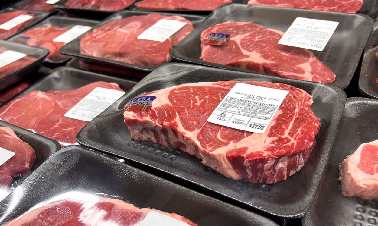 USDA Choice ribeye steaks on display at a grocery store.