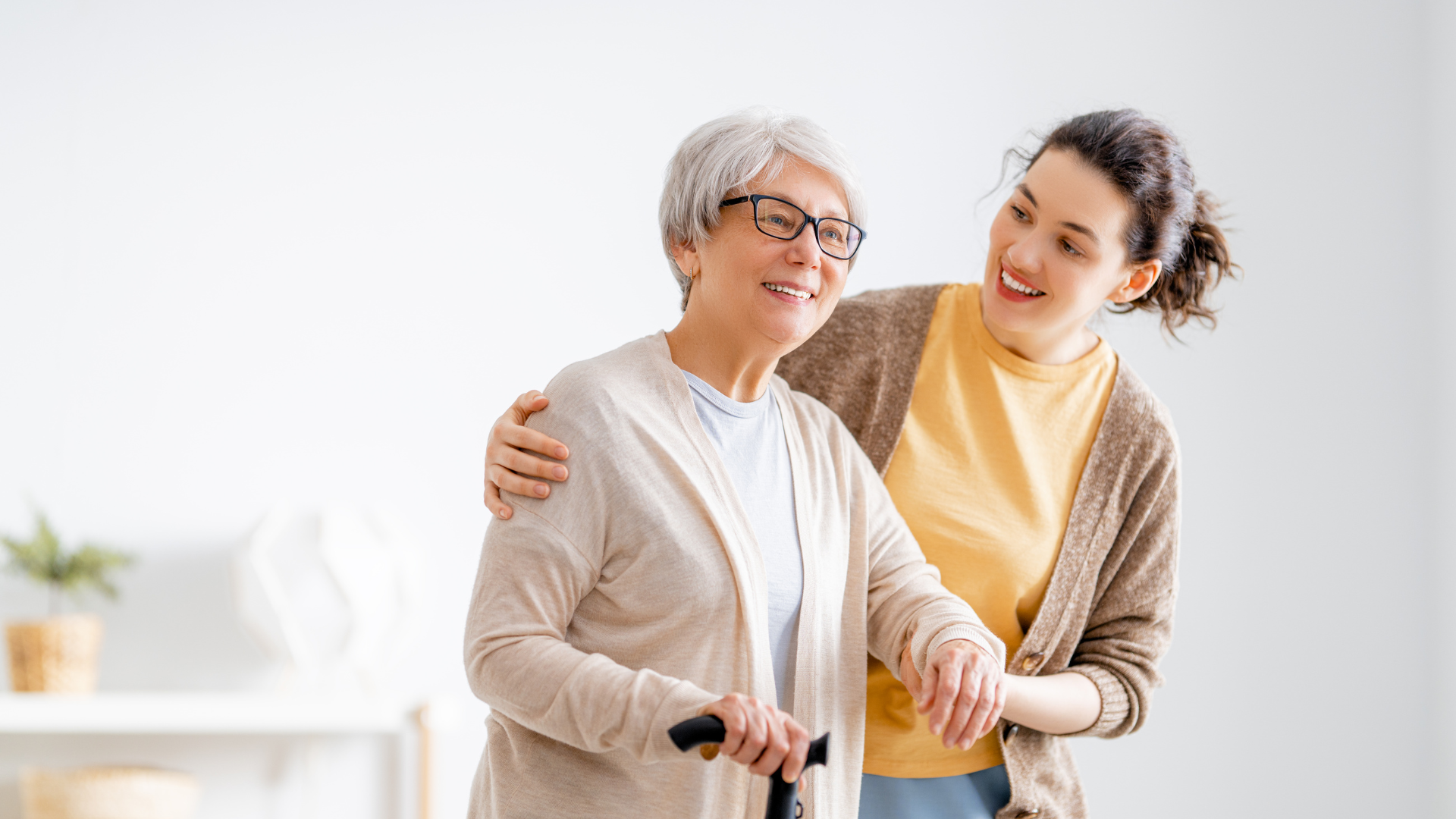 Woman caregiver helping older adult walk
