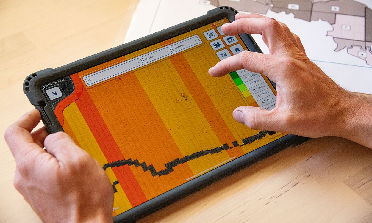 Producer reviewing precision planting information on a smart tablet.