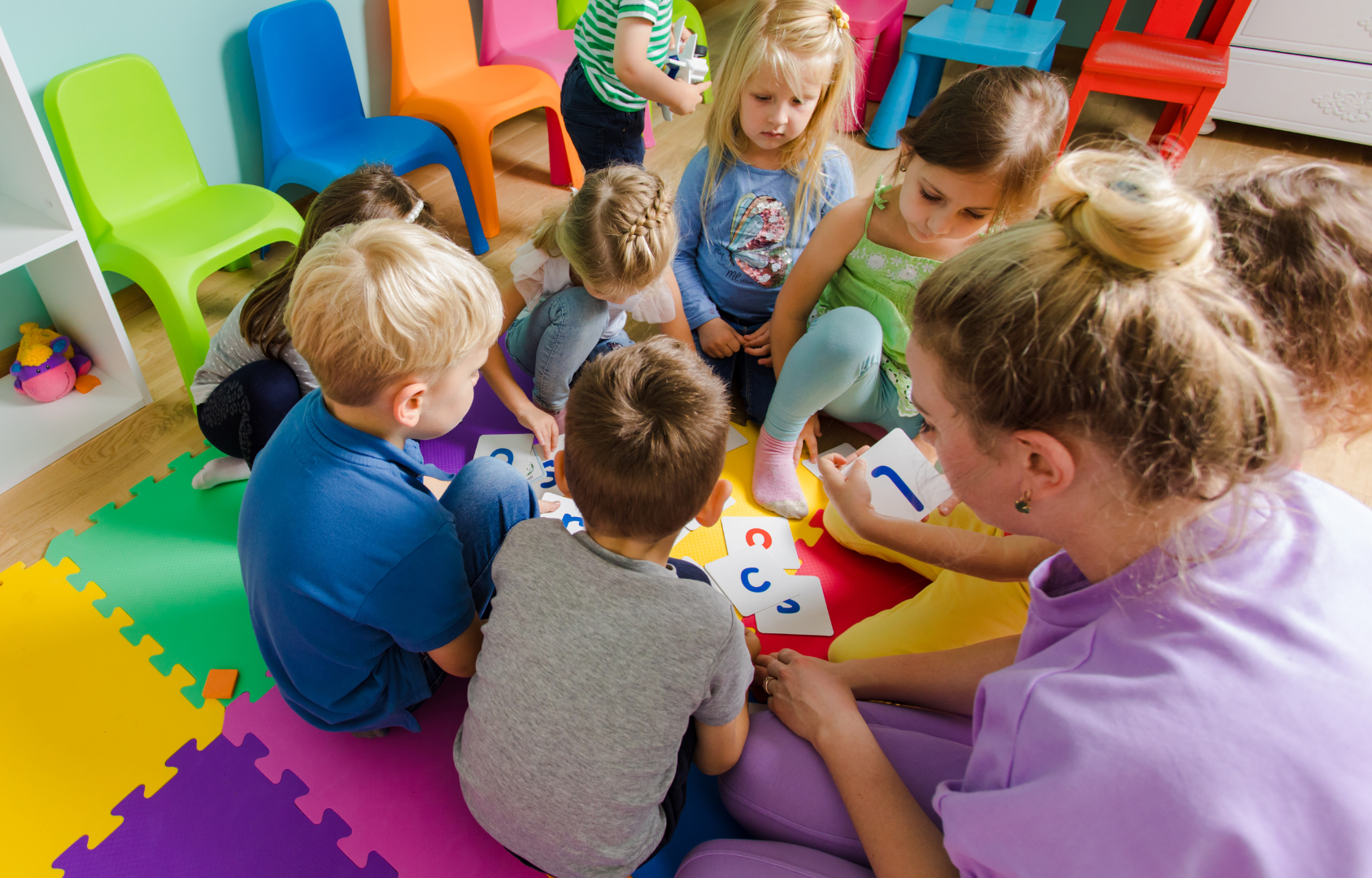 Group of children learning from childcare provider