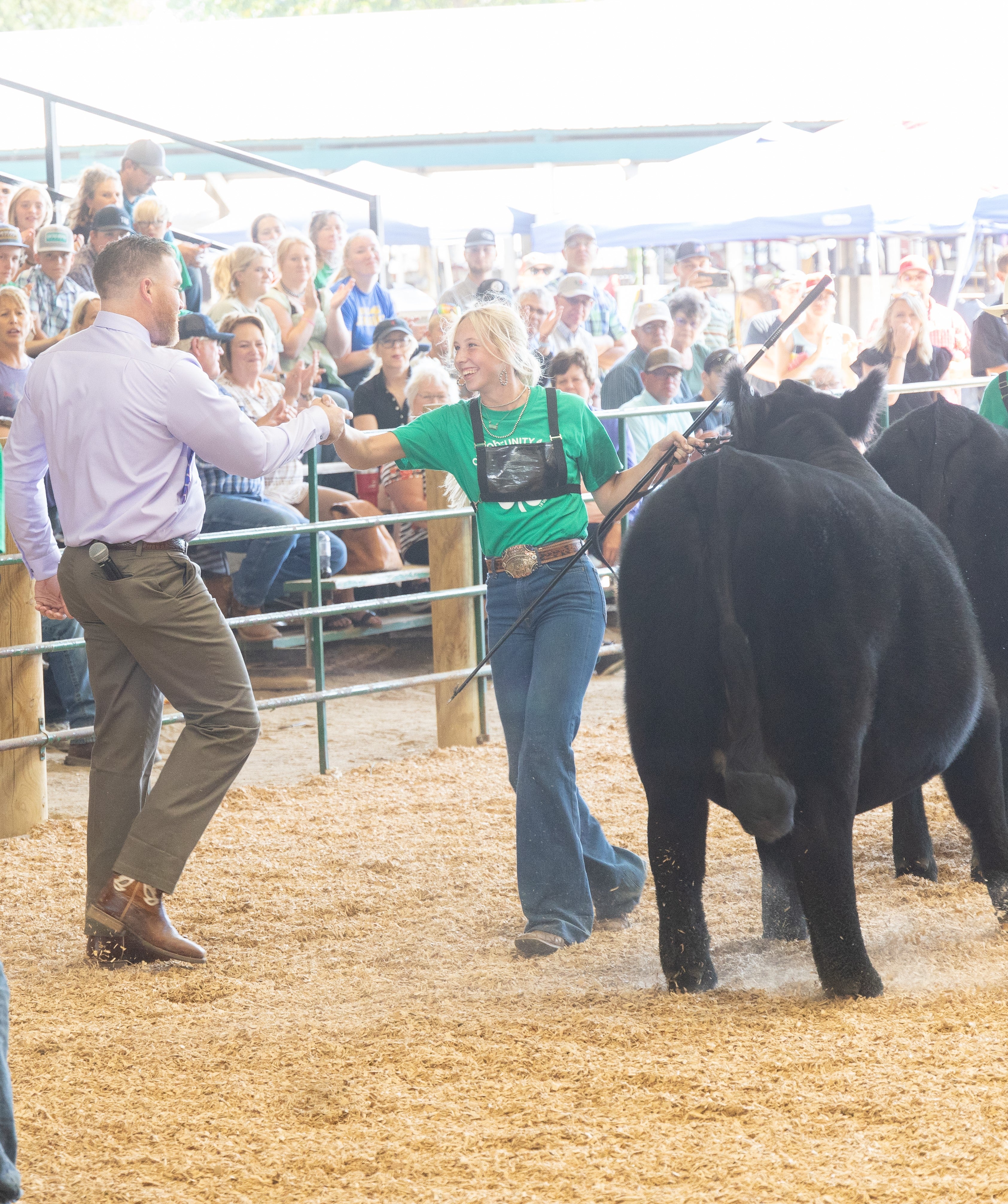 Adult male shaking a teenage girl's hand during State Fair