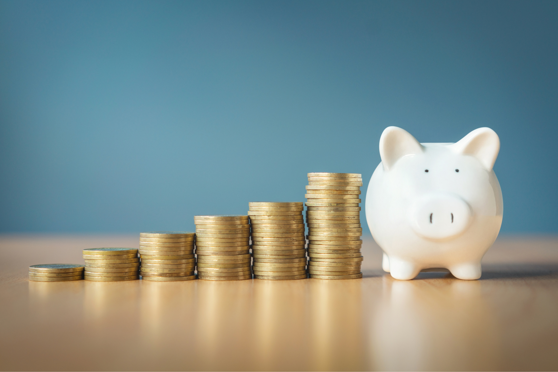 A piggy bank with stacks of coins next to it.