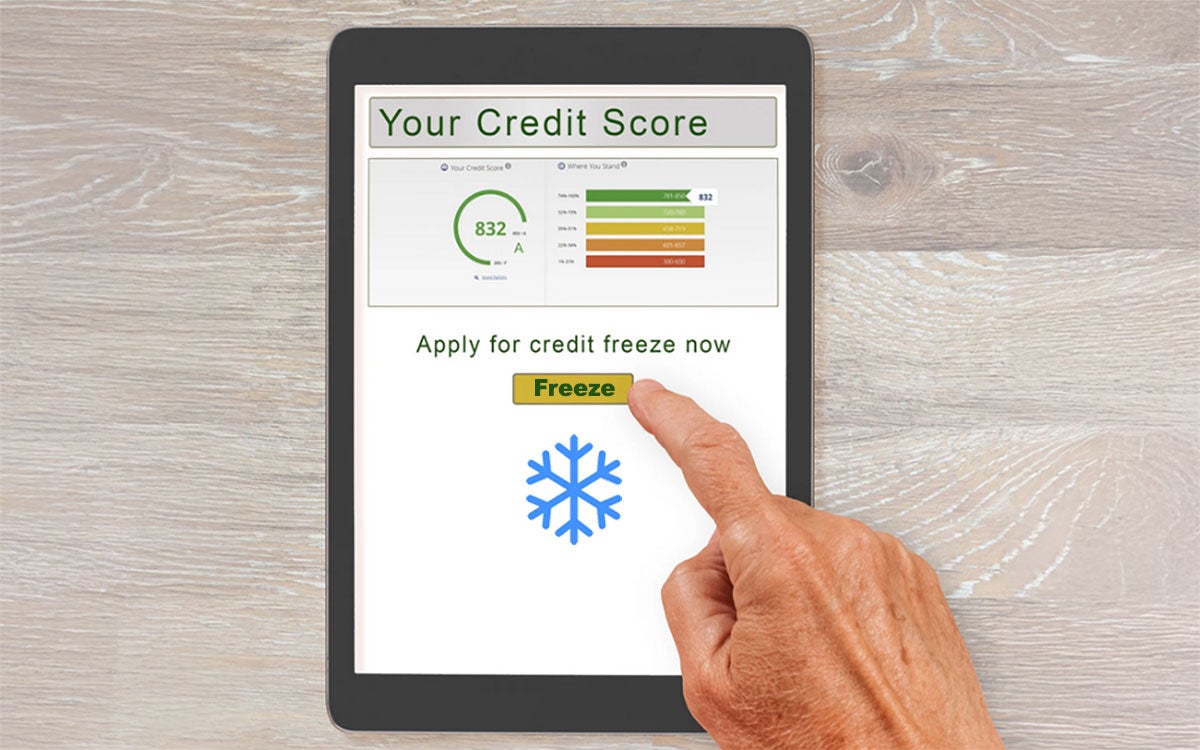 Hand tapping a button on a tablet computer to apply for a credit freeze.