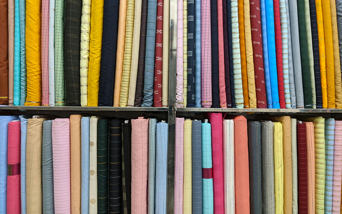 Rolls of colorful fabric on display at a store.