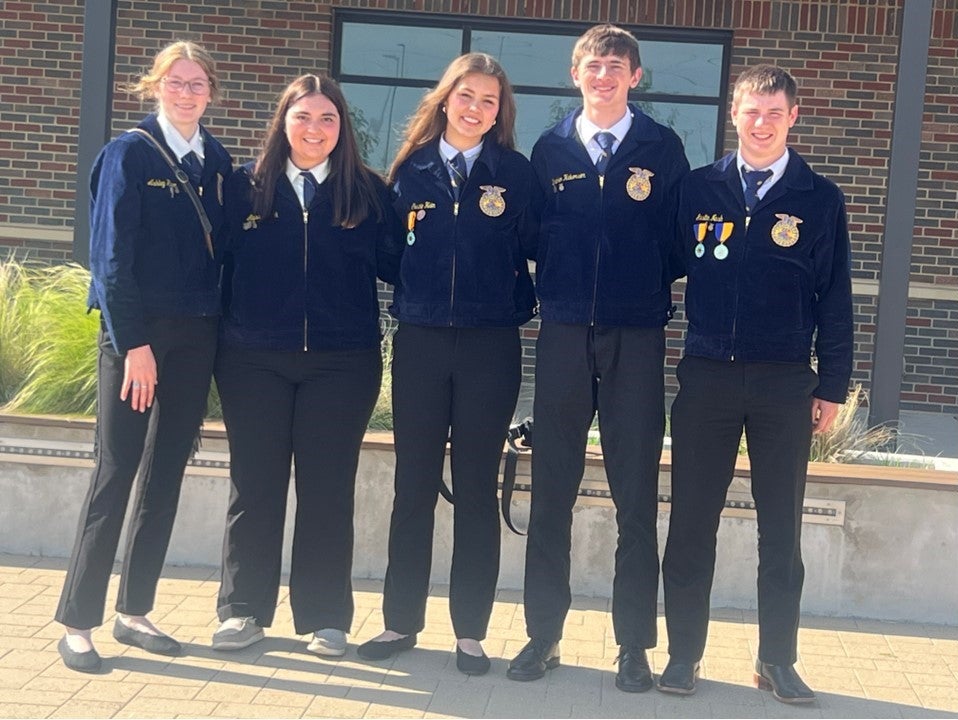 Five youth in matching FFA jackets pose for a team photo