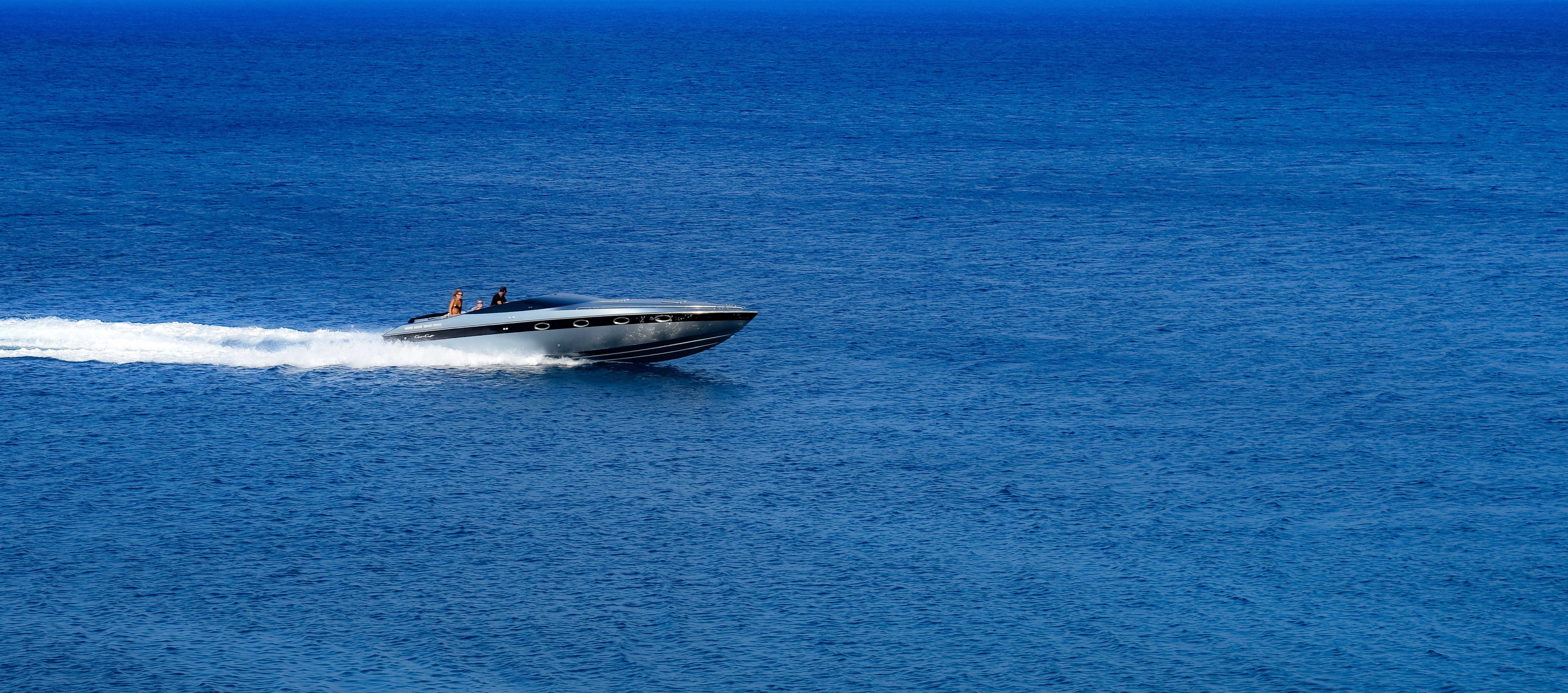 Speedboat racing across a blue body of water
