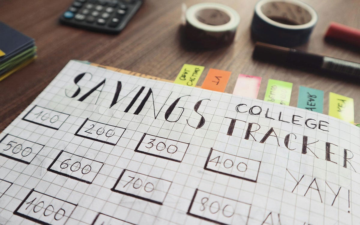 Savings notebook and budgeting materials on a tabletop.