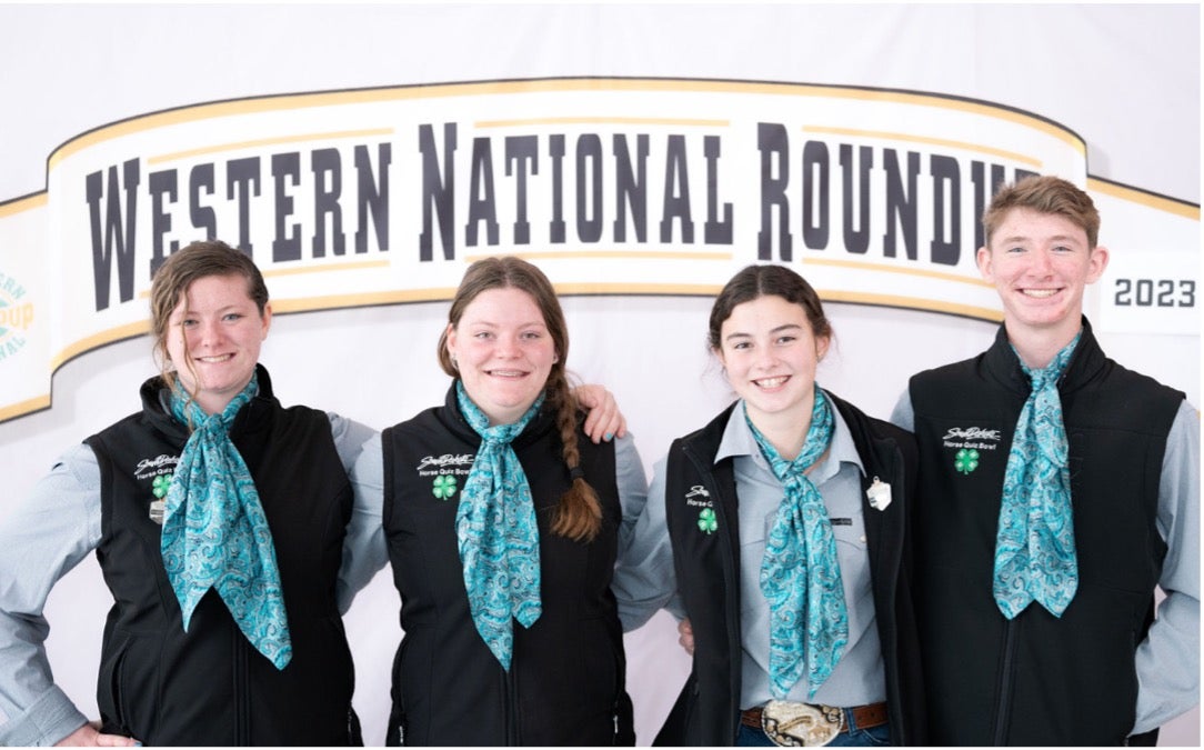The horse quiz bowl team smiles at the camera with their ribbons