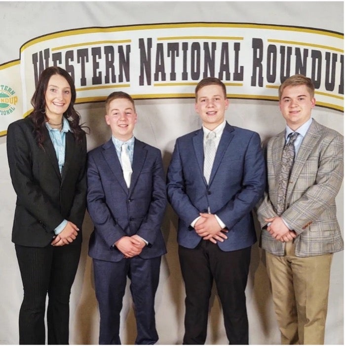 The 2024 livestock judging team smiles in front of a Western National Roundup backdrop
