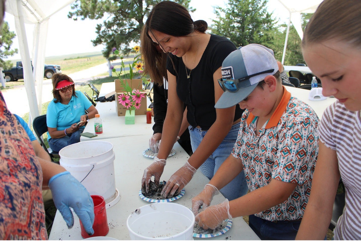 Youth smile as they roll soil into balls
