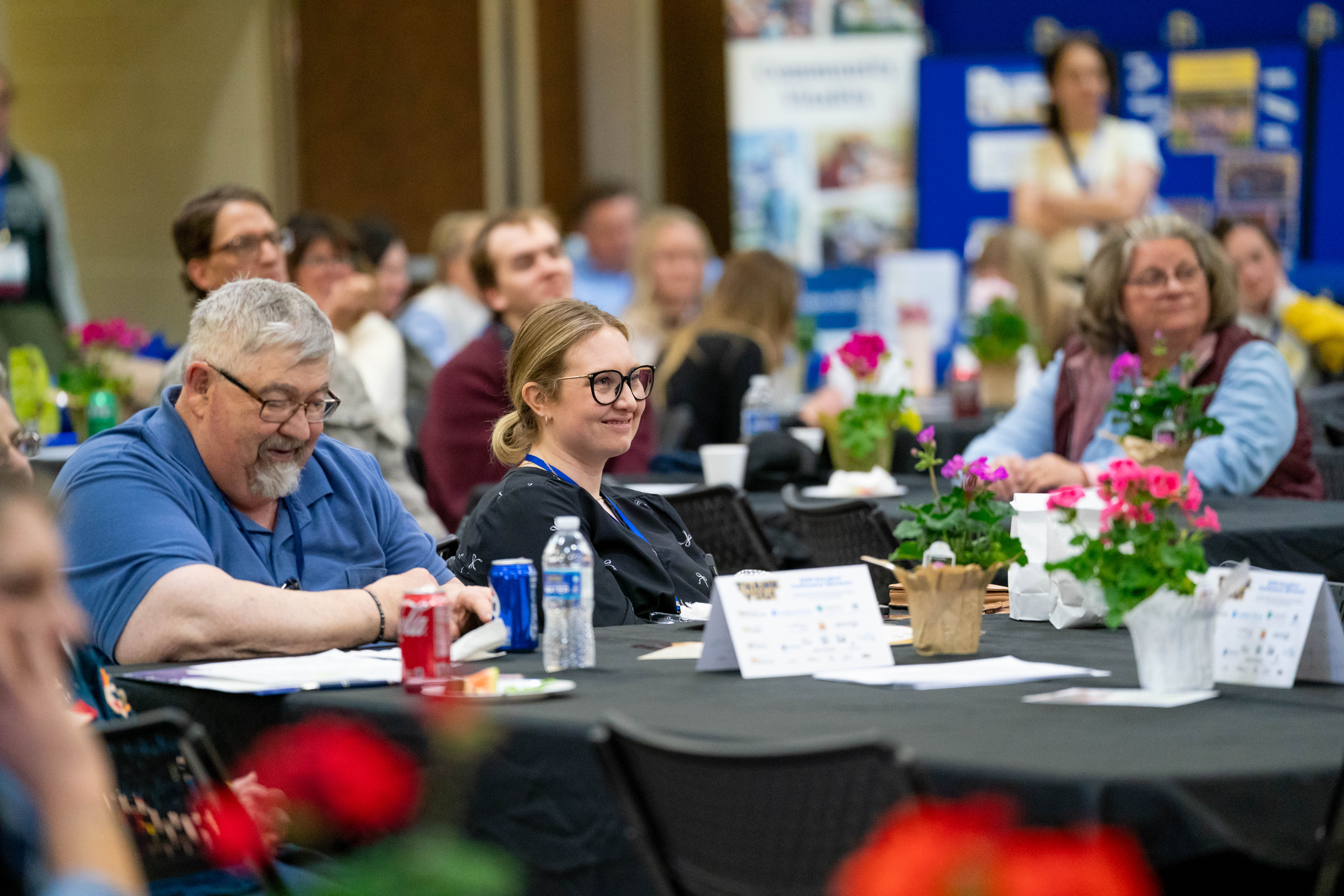 A woman smiles while listening to a speaker during Energize