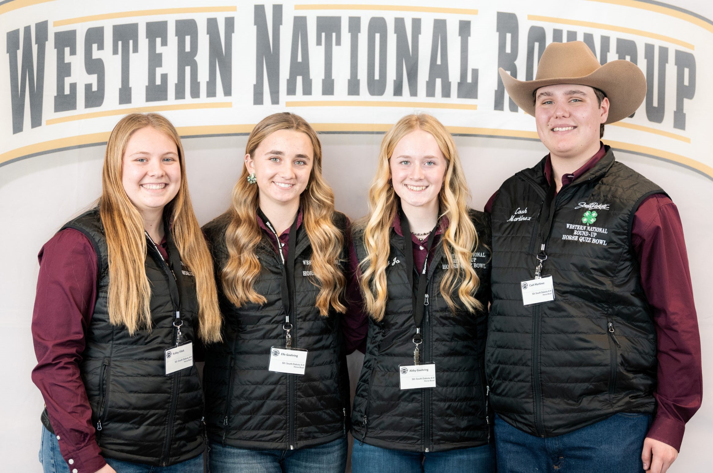 Three girls and a boy wearing a cowboy hat smile for the camera
