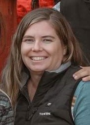 A woman smiles at the camera