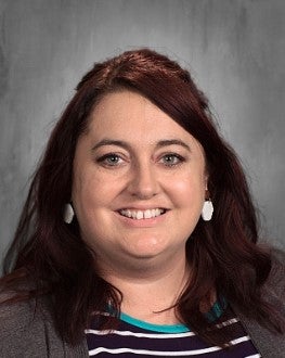 A woman smiles at the camera