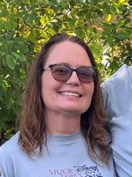 A woman smiles at the camera