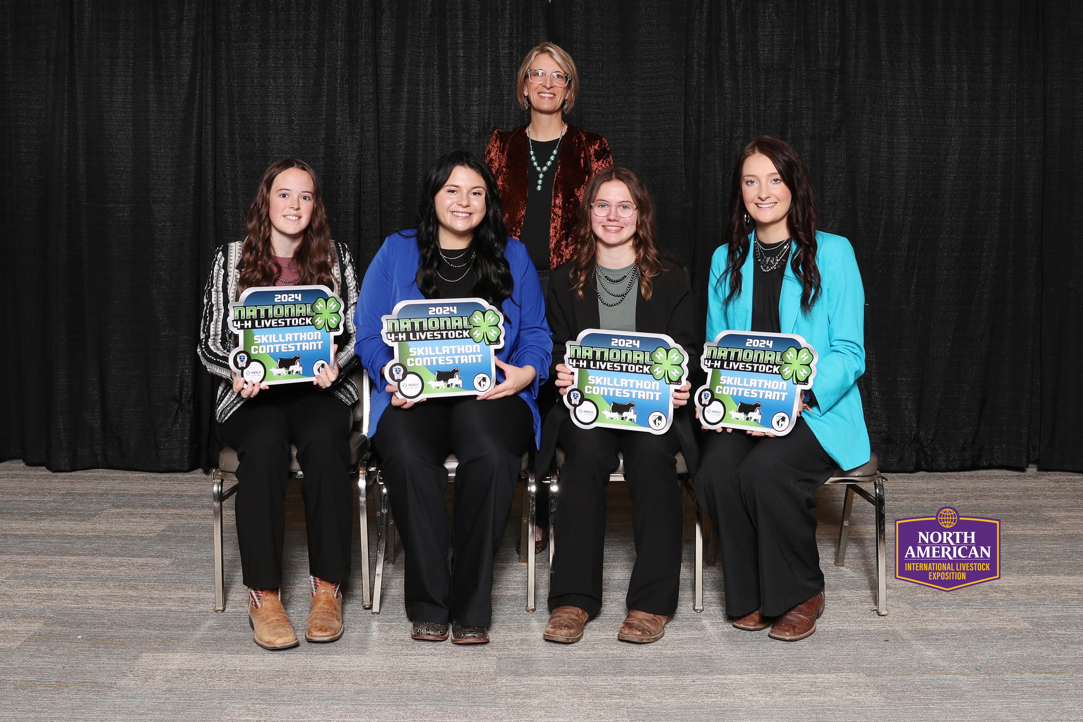 Youth smile for the camera holding awards plaques