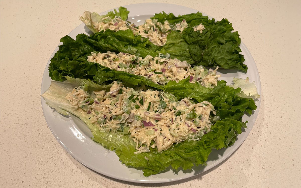 Shredded chicken salad lettuce wraps on a plate.